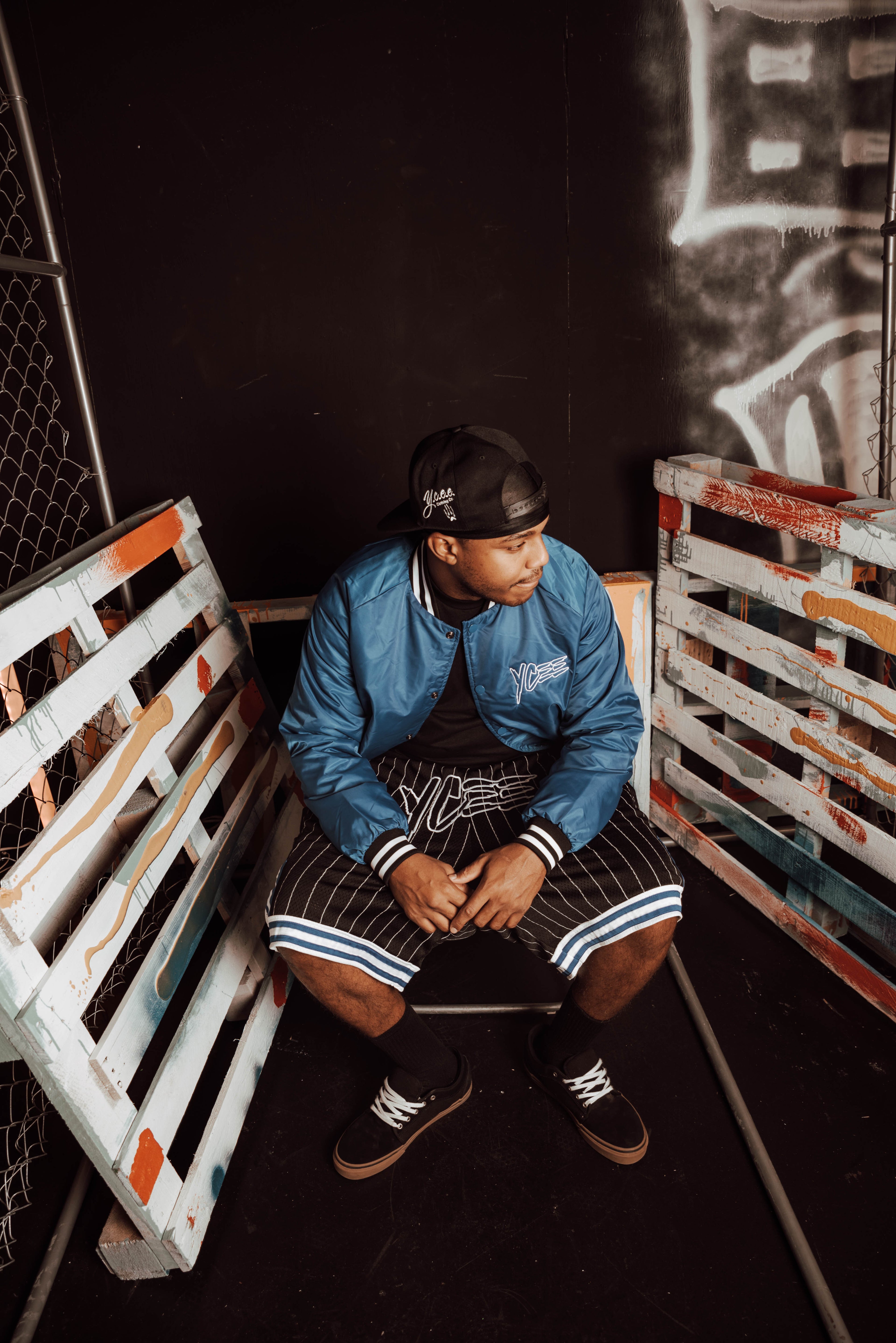 Person sitting on a pallet bench with a dark background