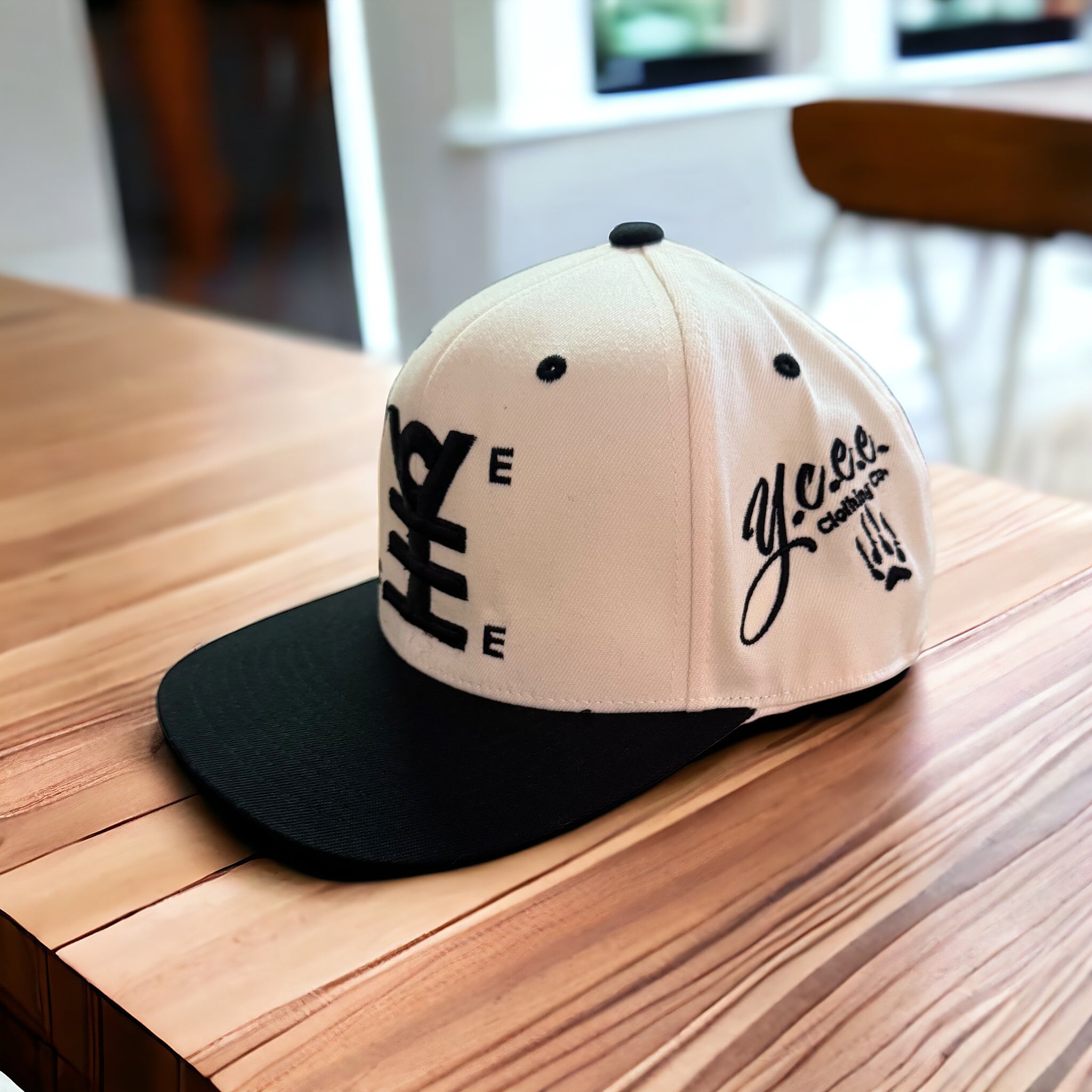 Beige and black cap with branding on a wooden surface
