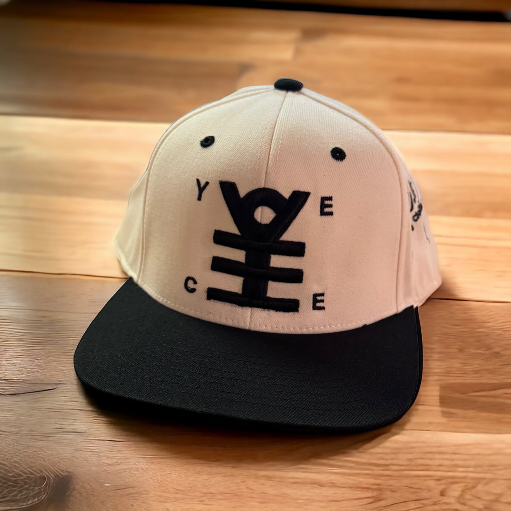 Beige and black cap with a logo on a wooden surface
