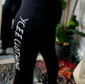 Black leggings with 'YCEE Clothing' text worn by a person, blurred background
